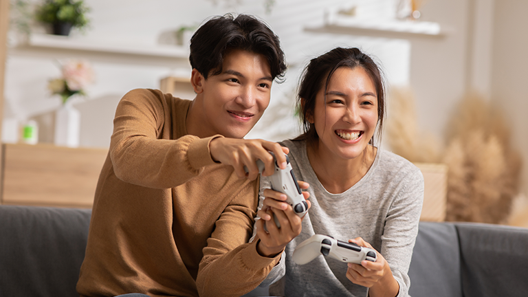 Asian couple playing games in the living room